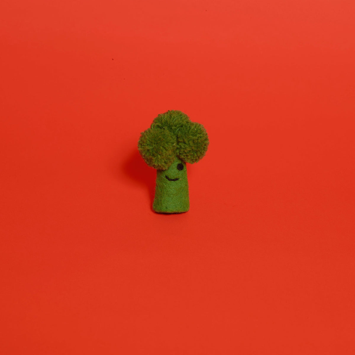 Ware of the Dog felted wool broccoli cat toy with smiling face on red background