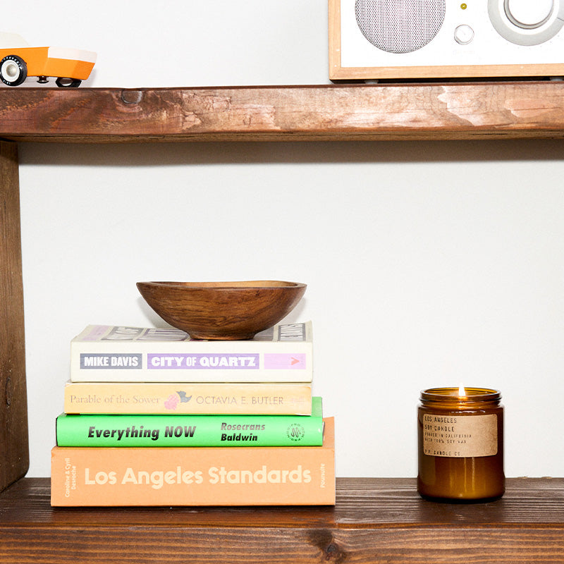P.F. Candle Co. Standard Candle in Los Angeles on a wood shelf with books