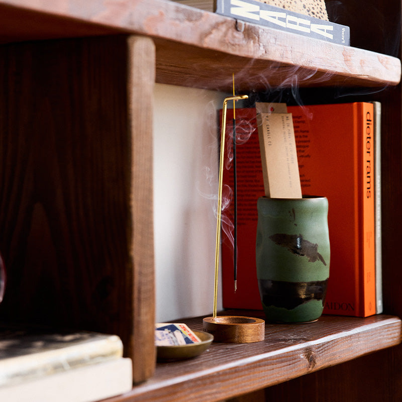 P.F. Candle Co. Incense Sticks in Piñon burning on a wood shelf