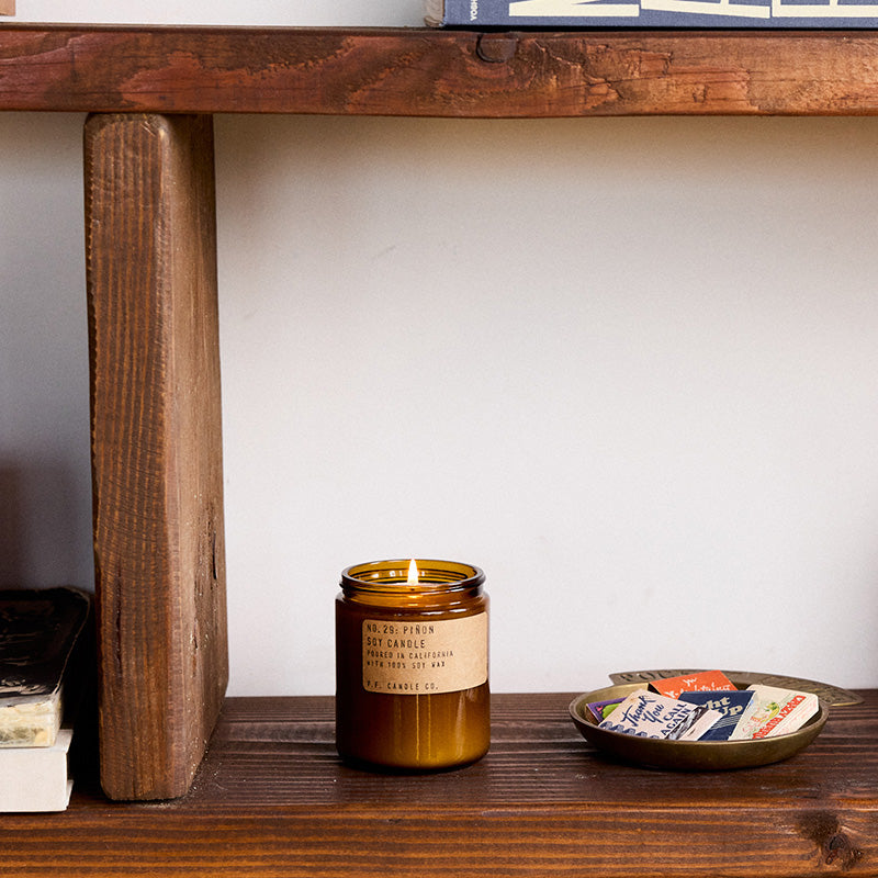 P.F. Candle Co. Standard Candle in Piñon on a wood console with a dish