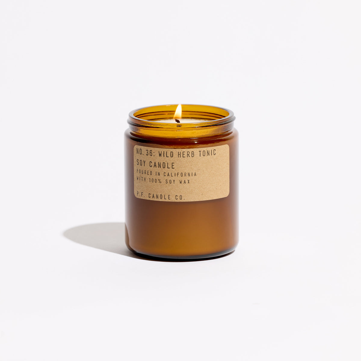 P.F. Candle Co. Standard Candle in Wild Herb Tonic, 7.2 oz amber glass jar with brass lid