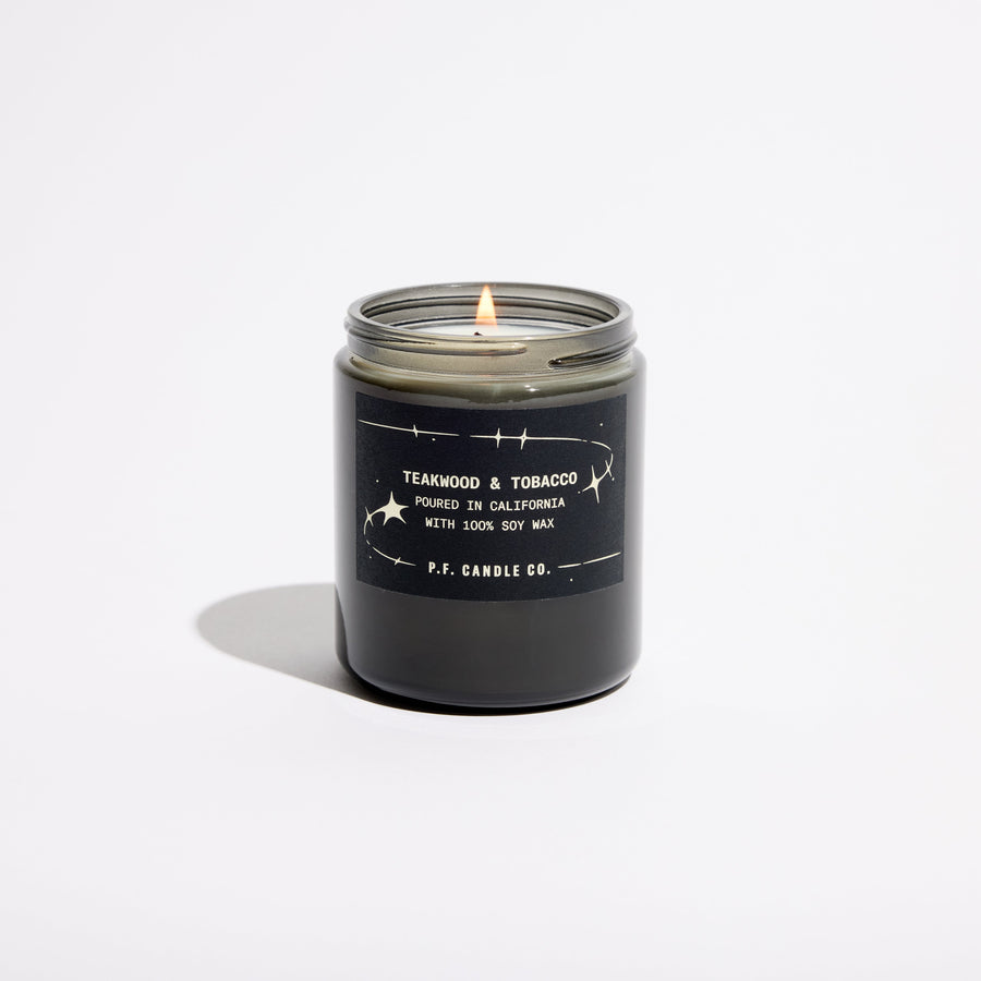 P.F. Candle Co. Celestial Collection Candle in Teakwood & Tobacco, smoky grey glass jar with black lid