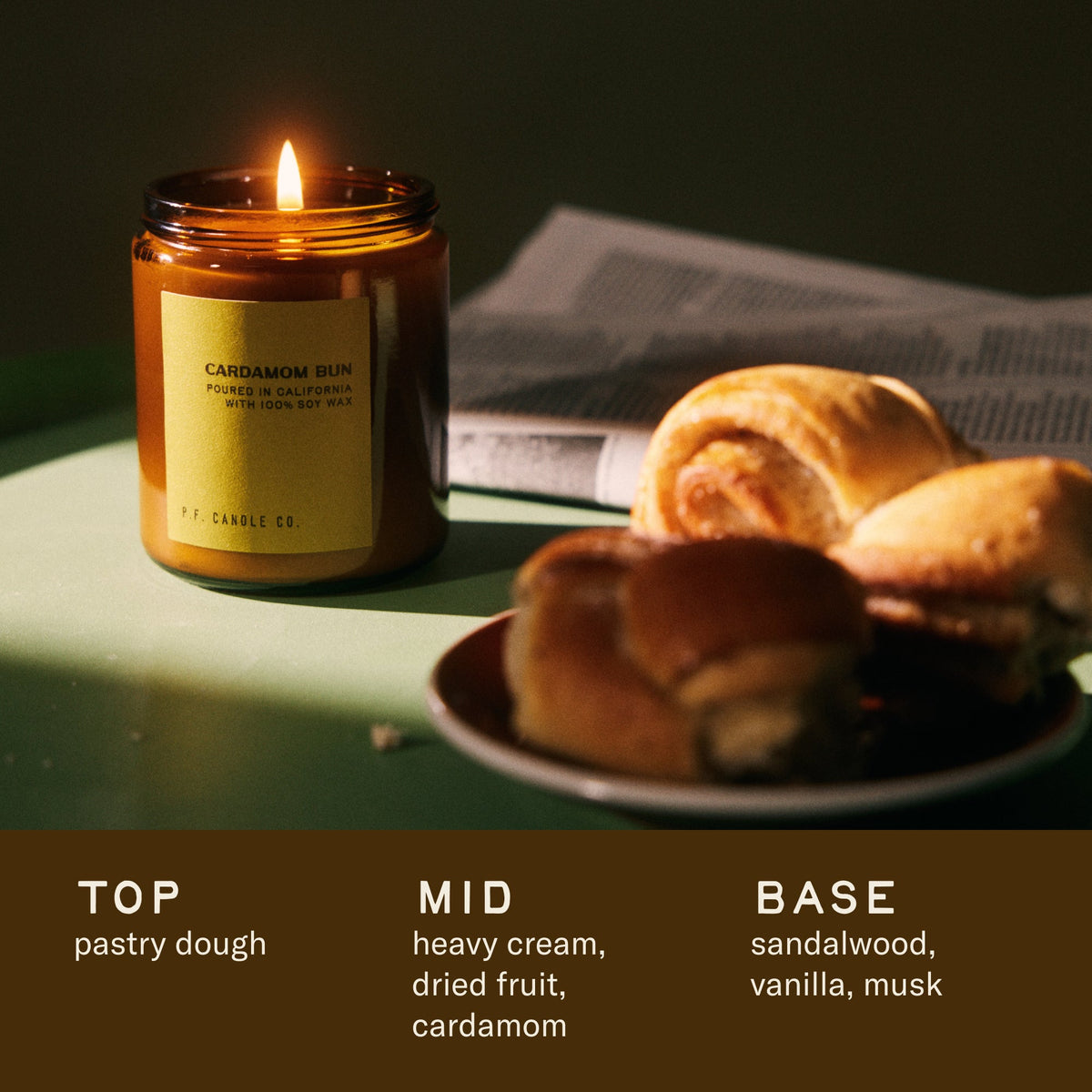 P.F. Candle Co. Cardamom Bun Standard Candle with pastries and scent notes: pastry dough, heavy cream, dried fruit, cardamom, sandalwood, vanilla, musk