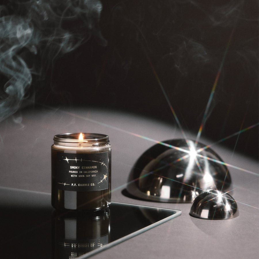 P.F. Candle Co. Celestial Collection Candle in Smoky Cinnamon lit on a dark table