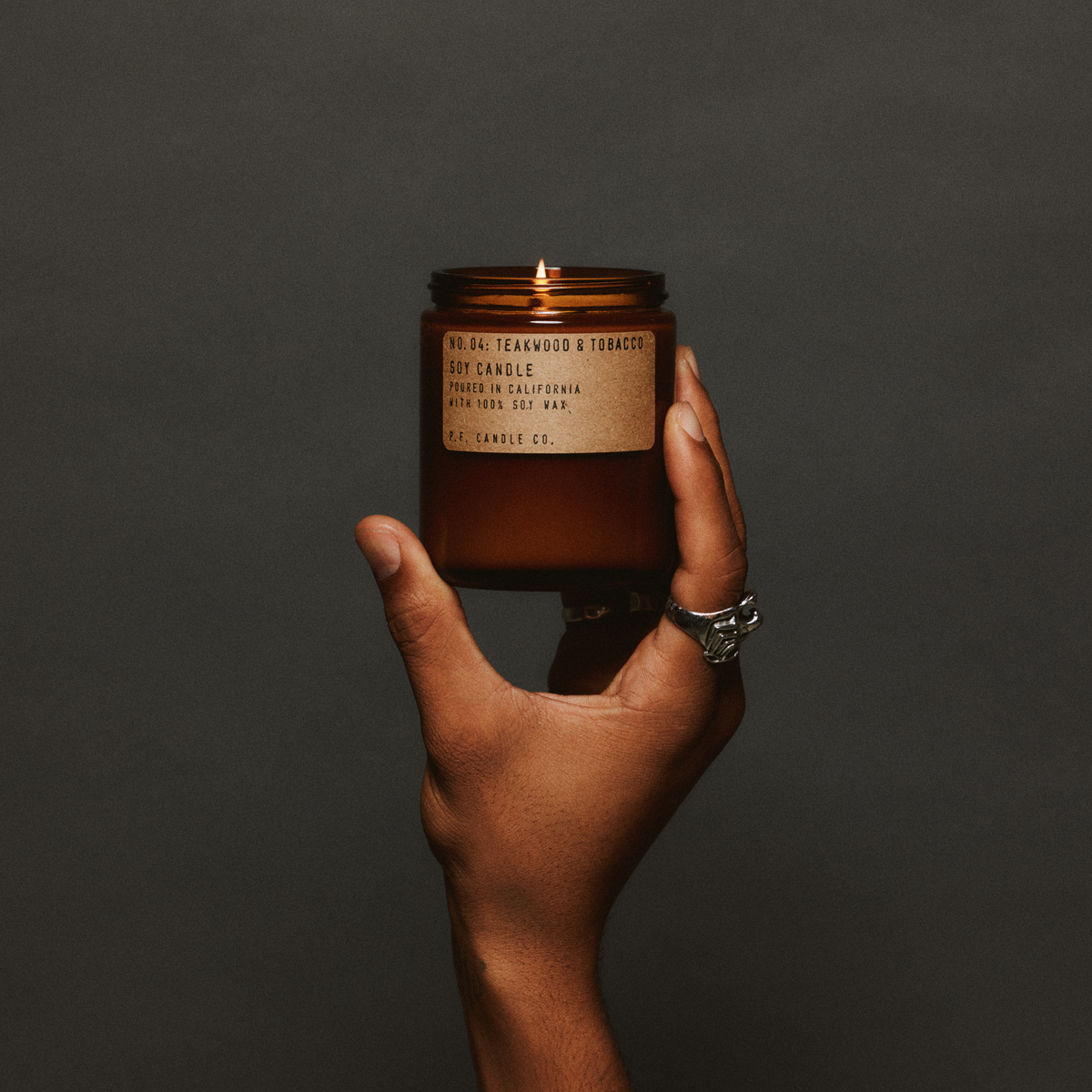 P.F. Candle Co. Standard Candle in Teakwood & Tobacco held in hand
